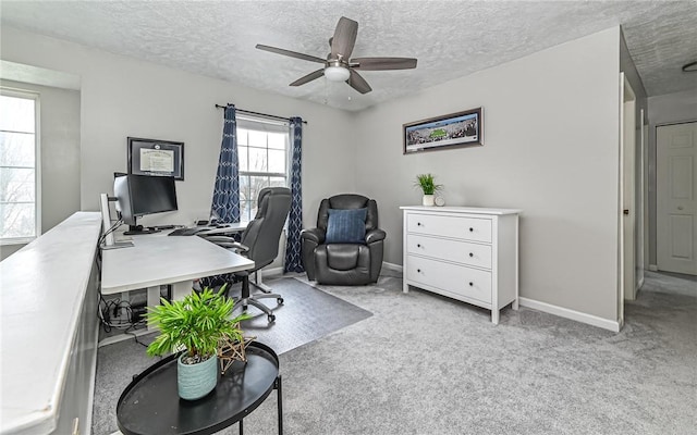 carpeted office space featuring ceiling fan and a textured ceiling