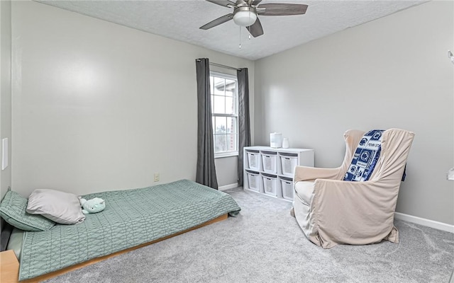 carpeted bedroom featuring ceiling fan and a textured ceiling