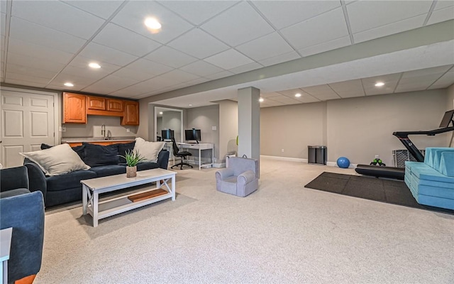 carpeted living room featuring a paneled ceiling and sink