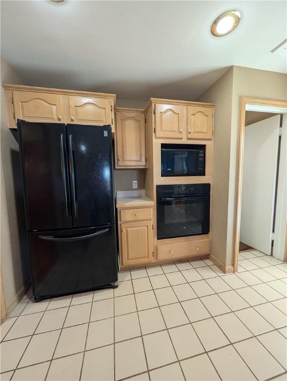 kitchen featuring light brown cabinets, light tile patterned floors, and black appliances