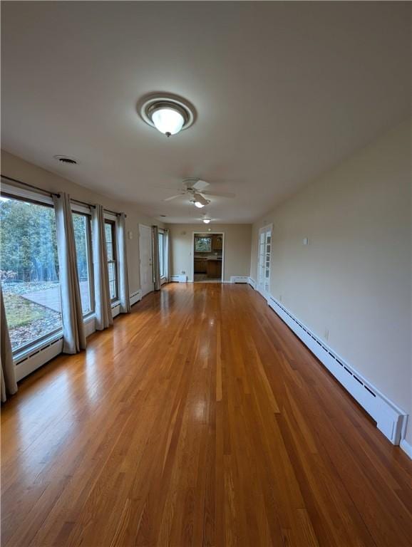 unfurnished living room featuring ceiling fan, a baseboard radiator, and light hardwood / wood-style floors