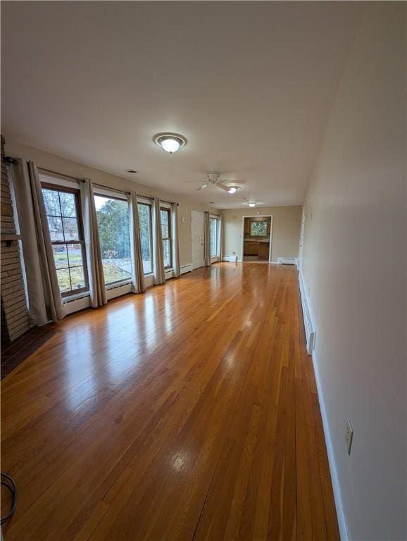 unfurnished living room featuring ceiling fan, light wood-type flooring, and a fireplace