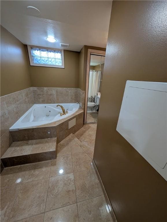 bathroom featuring a relaxing tiled tub and toilet