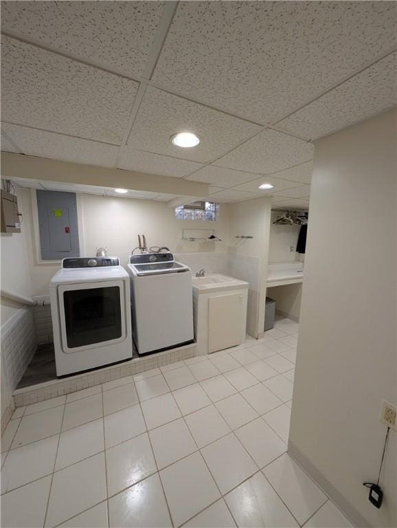 laundry area featuring electric panel, washer and clothes dryer, and light tile patterned flooring