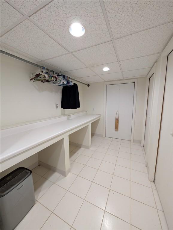 mudroom with a drop ceiling and light tile patterned floors