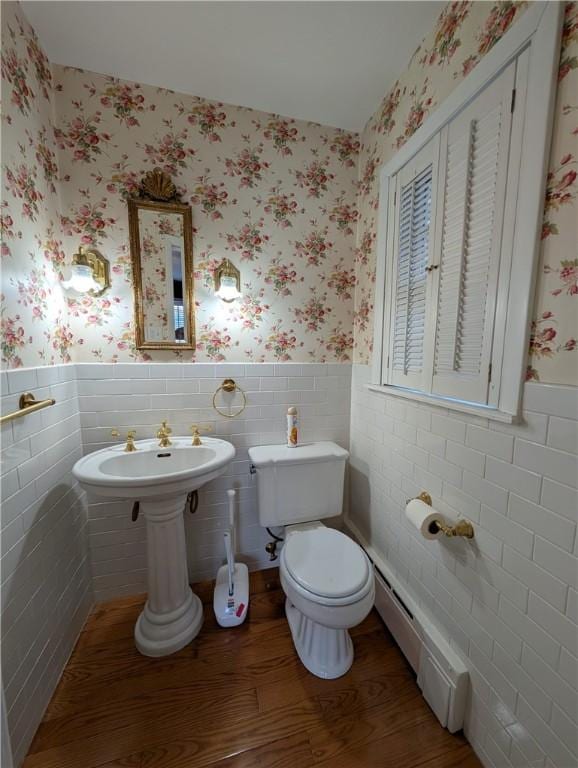 bathroom featuring toilet, wood-type flooring, and a baseboard radiator