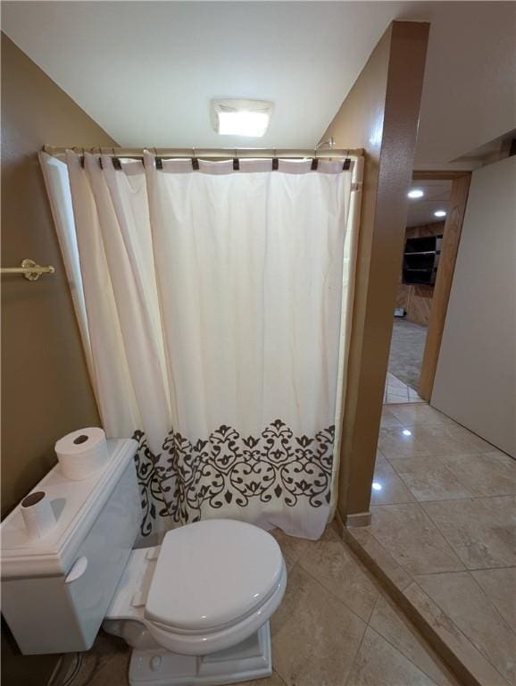 bathroom with tile patterned floors, a shower with curtain, and toilet