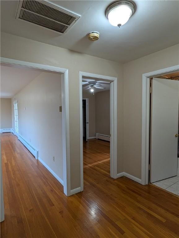 corridor with a baseboard radiator and light wood-type flooring