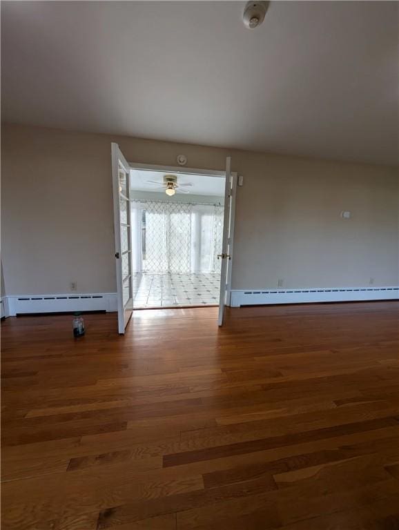 unfurnished room with ceiling fan, dark hardwood / wood-style flooring, and a baseboard heating unit