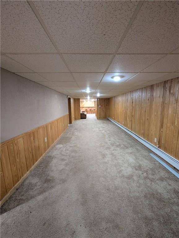 basement featuring a drop ceiling and carpet floors