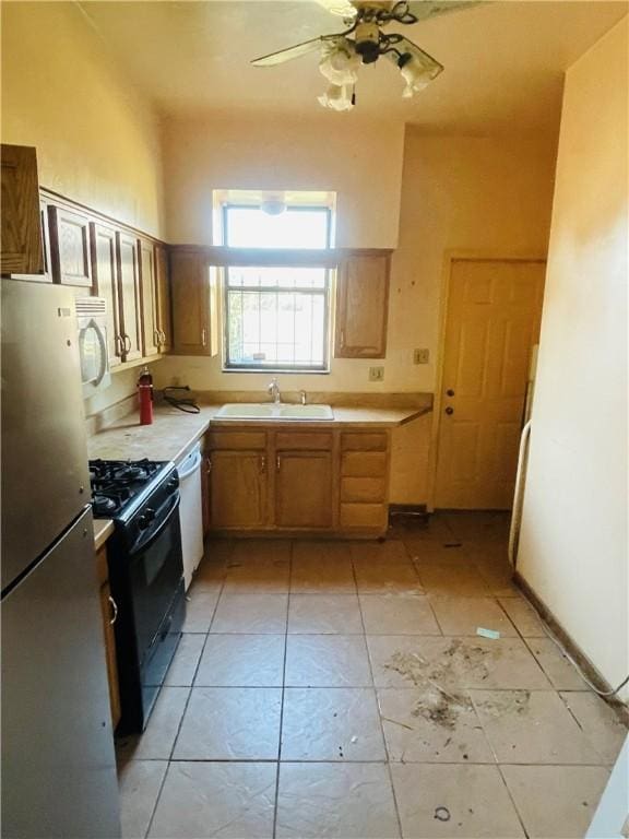 kitchen featuring ceiling fan, white appliances, sink, and light tile patterned floors