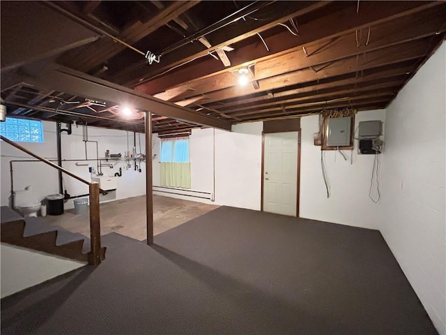 basement with electric panel and a baseboard heating unit