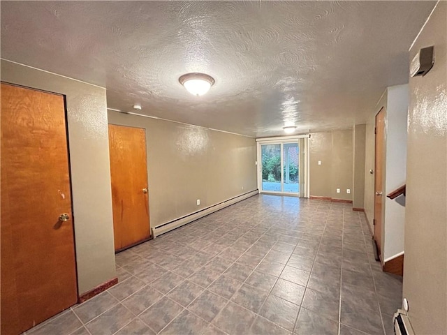 spare room with a textured ceiling and a baseboard heating unit