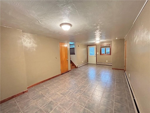 empty room featuring baseboard heating and a textured ceiling