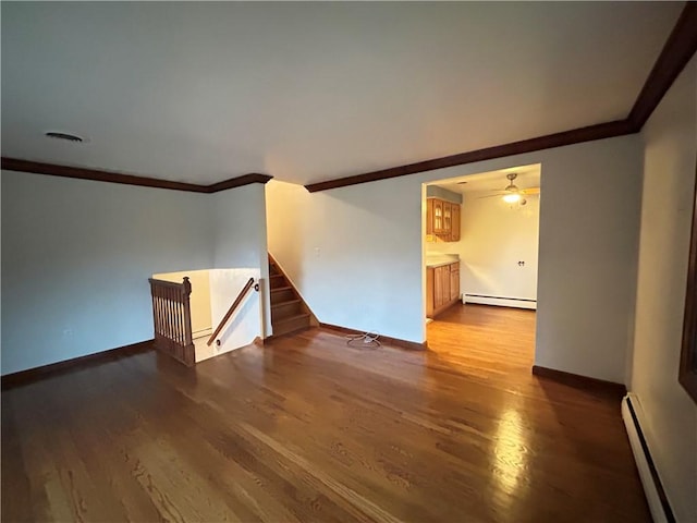 empty room with ceiling fan, ornamental molding, a baseboard radiator, and wood-type flooring