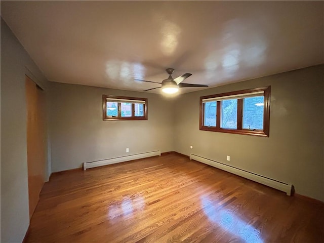 empty room with a baseboard radiator, light hardwood / wood-style flooring, and ceiling fan