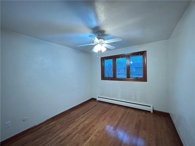 spare room with dark hardwood / wood-style floors, ceiling fan, and baseboard heating