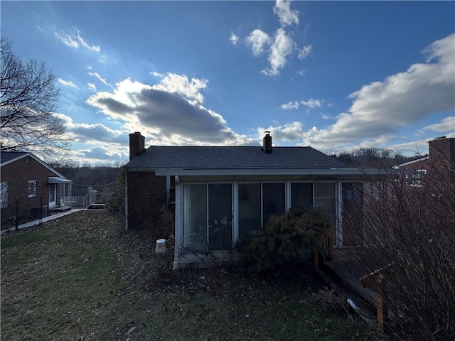 rear view of house featuring a sunroom