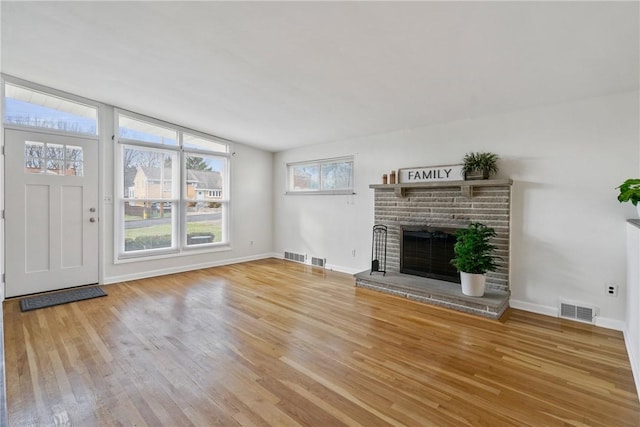 unfurnished living room featuring a fireplace, light wood-type flooring, and vaulted ceiling