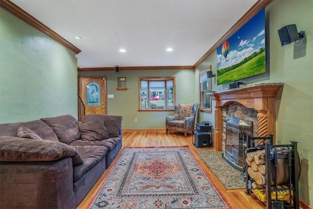 living room featuring light hardwood / wood-style flooring, ornamental molding, and a stone fireplace