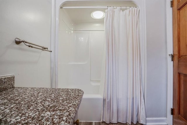 bathroom featuring hardwood / wood-style floors and shower / bath combination with curtain