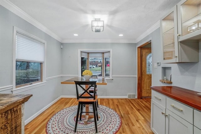 dining room with light hardwood / wood-style floors and ornamental molding