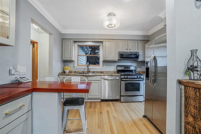 kitchen featuring gray cabinets, sink, appliances with stainless steel finishes, and light hardwood / wood-style flooring