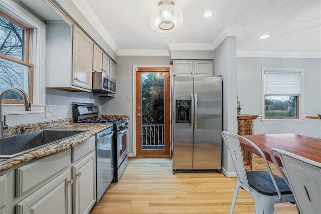 kitchen featuring a healthy amount of sunlight, light wood-type flooring, sink, and appliances with stainless steel finishes