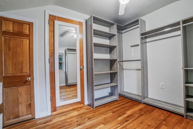 walk in closet with light wood-type flooring and ceiling fan