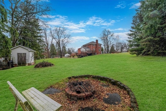 view of yard with a storage unit and an outdoor fire pit