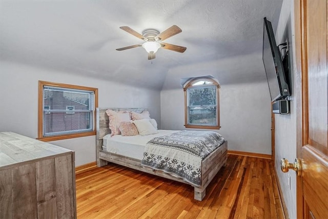 bedroom featuring ceiling fan, wood-type flooring, and lofted ceiling