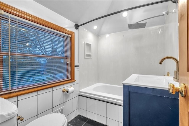 full bathroom with tiled shower / bath combo, tile patterned flooring, vaulted ceiling, toilet, and vanity