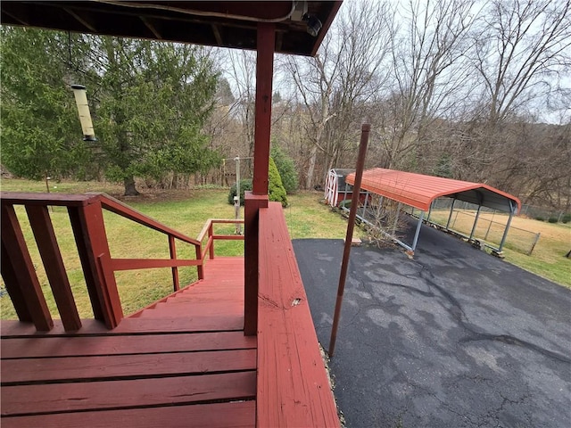 wooden terrace with a yard and a carport