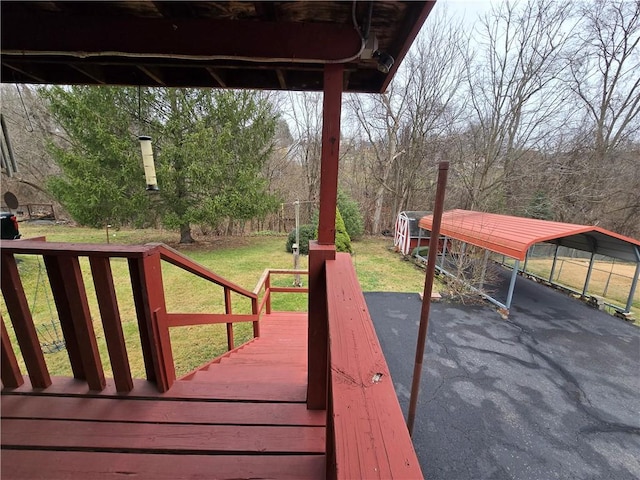 wooden deck with a lawn and a carport