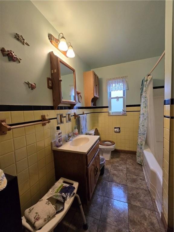 full bathroom with vanity, shower / tub combo with curtain, tile walls, tile patterned flooring, and toilet