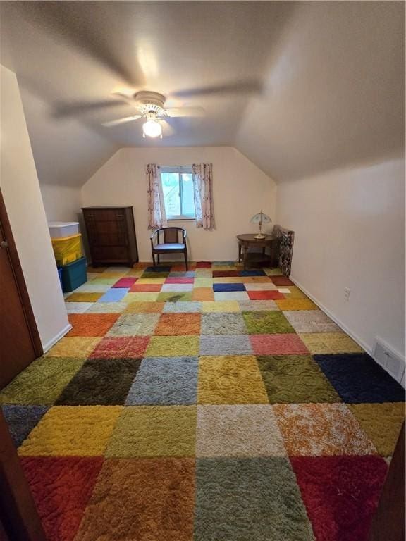 interior space with ceiling fan, carpet floors, and vaulted ceiling