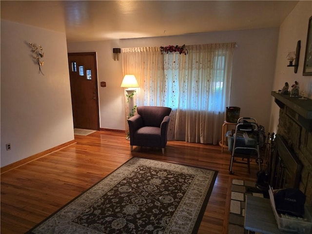 sitting room with a fireplace and wood-type flooring