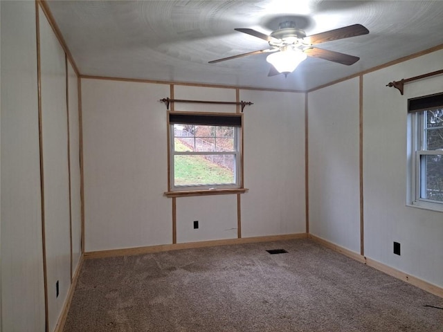 carpeted empty room with ceiling fan and crown molding