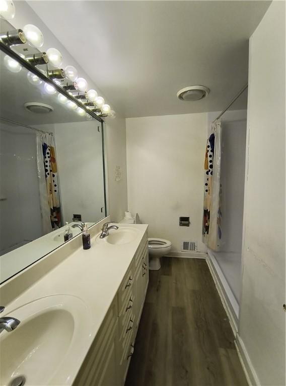 bathroom featuring a shower with shower curtain, vanity, toilet, and wood-type flooring