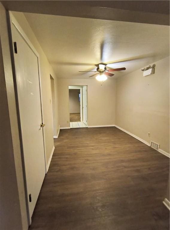 spare room with ceiling fan and dark wood-type flooring