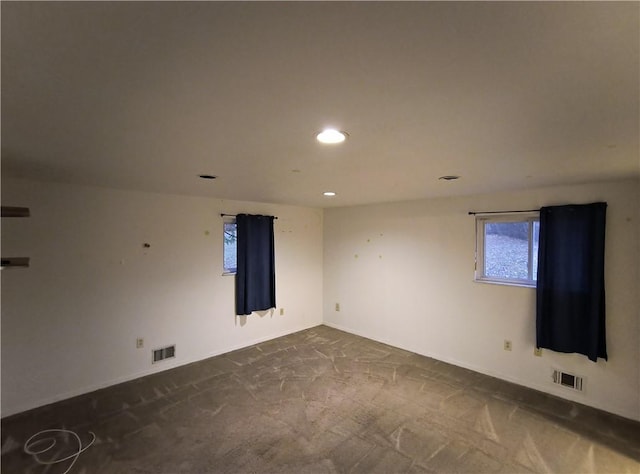 unfurnished room with dark colored carpet