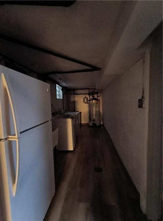 basement with washer / dryer, gas water heater, fridge, and dark wood-type flooring