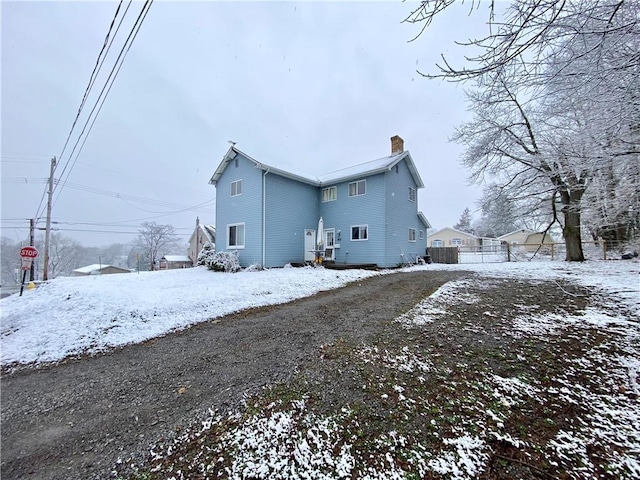 view of snow covered back of property