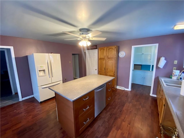 kitchen with dark hardwood / wood-style flooring, dishwasher, white fridge with ice dispenser, and a kitchen island