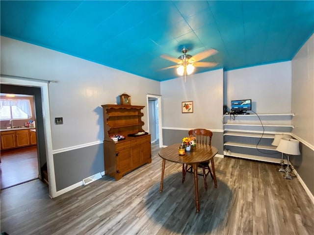 living area with ceiling fan, sink, and wood-type flooring