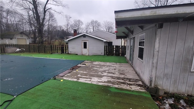 deck featuring an outbuilding and a covered pool