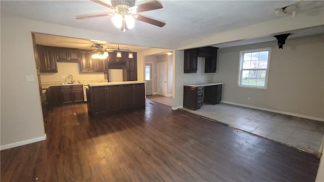 kitchen featuring dark brown cabinets, a kitchen island, dark wood-type flooring, and sink