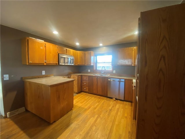 kitchen with sink, stainless steel appliances, and light hardwood / wood-style flooring