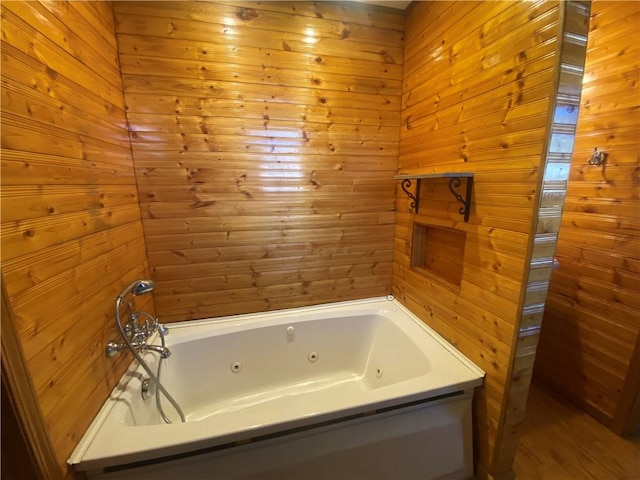 bathroom featuring a washtub and wooden walls