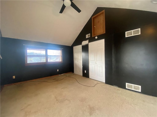 unfurnished bedroom with ceiling fan, lofted ceiling, and light carpet